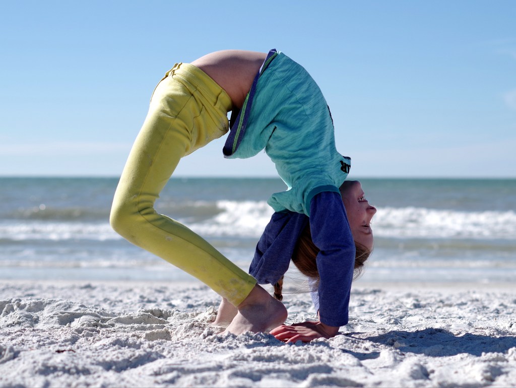 Practicing gymnastics at the beach