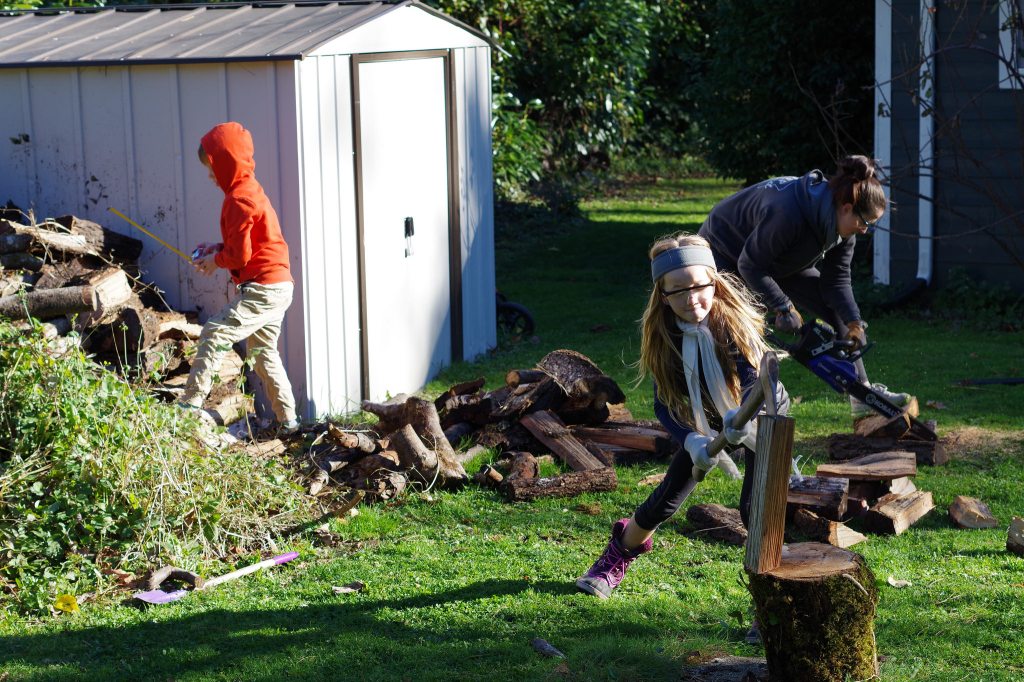 My 6-year-old son measuring firewood while my 8-year-old daughter splits kindling, and mommy handles the chainsaw.